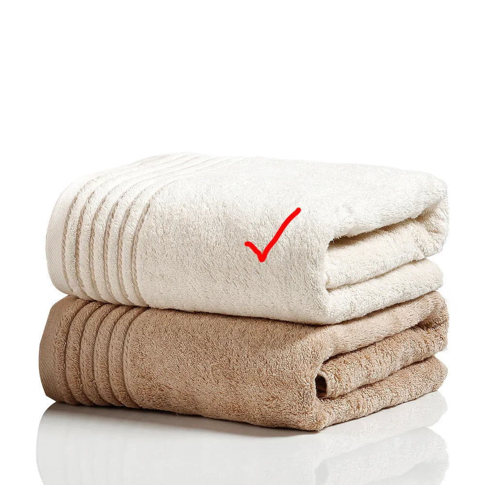 Set of three cotton towels in beige and brown including large bath towel, hand towel, and small washcloth
