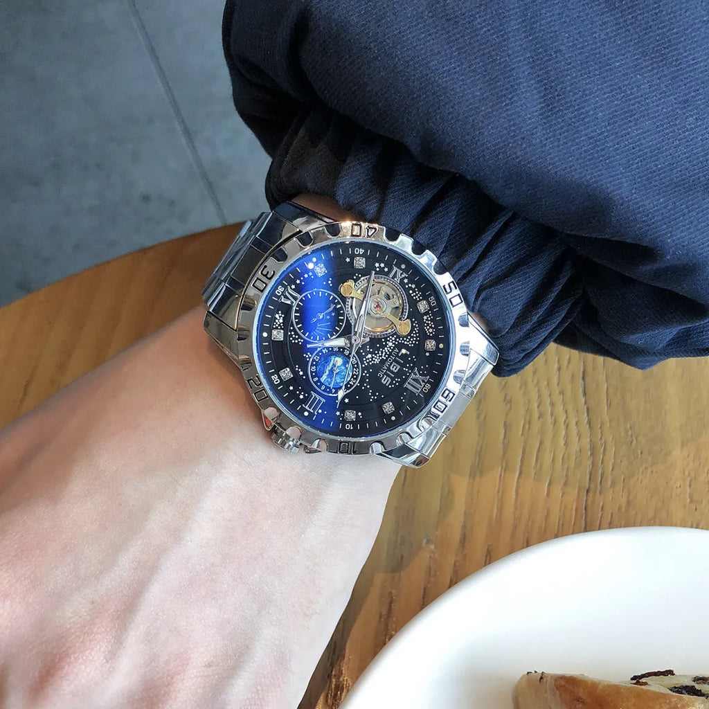 Men's silver case automatic watch with starry black luminous dial and brown leather strap.
