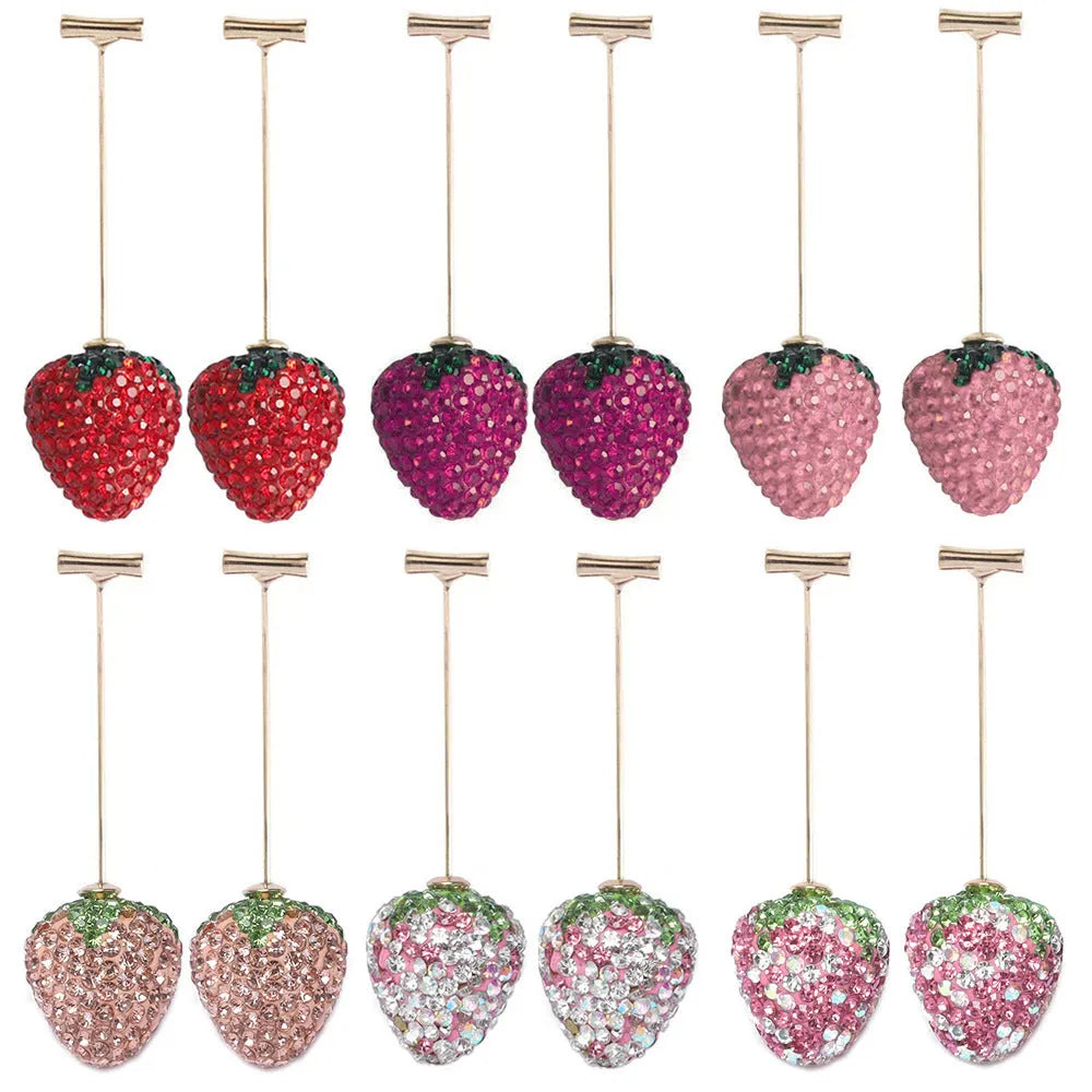 Close-up of women's geometric strawberry-shaped earrings with spot drill texture, on a red background.