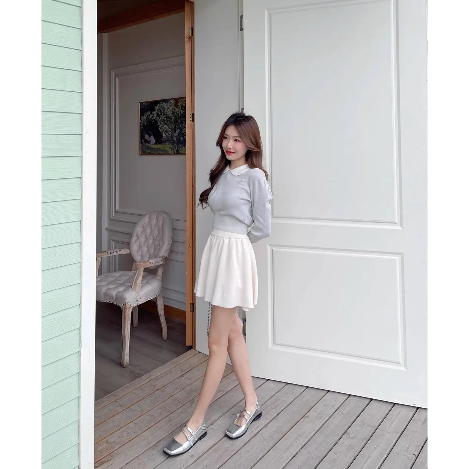 Women's silver leather Mary Jane flats with a cross-buckle strap and flat heel.