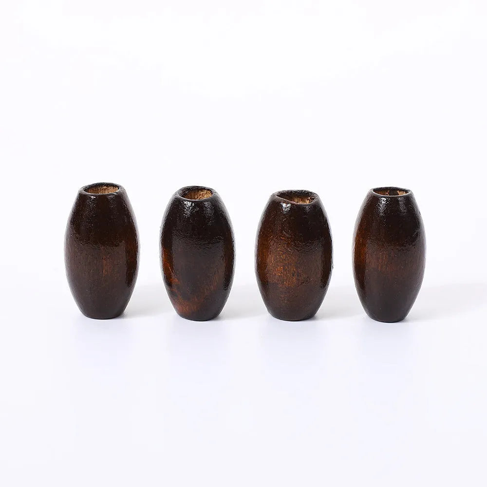 Dark coffee coloured oval wooden bead with an M-shaped raised design on a white background.