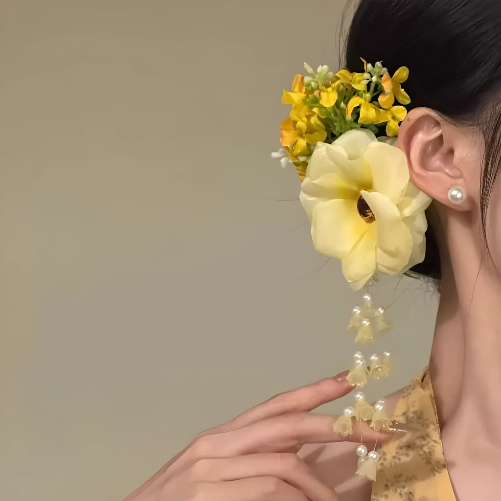 Handmade yellow and purple floral tassel hair clip for women on a white background.