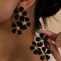 Retro flower-shaped clip-on earrings in black and white colour options