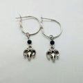 A pair of silver-coloured round hoop earrings with a Tibetan antelope design.