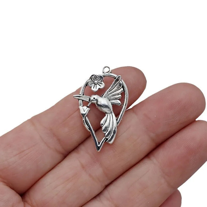 Close-up of a detailed magpie pattern alloy pendant with electroplated finish, showing attachment loop for DIY jewellery.