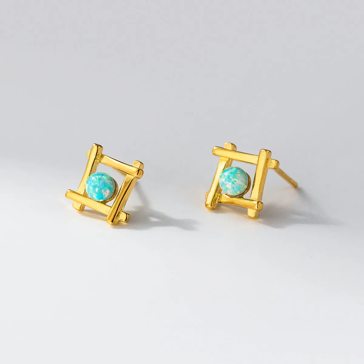 Geometric cross-shaped 925 silver stud earrings in gold and silver tone options.