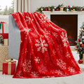 Soft red flannel Christmas blanket draped over a sofa, showing its plush texture.