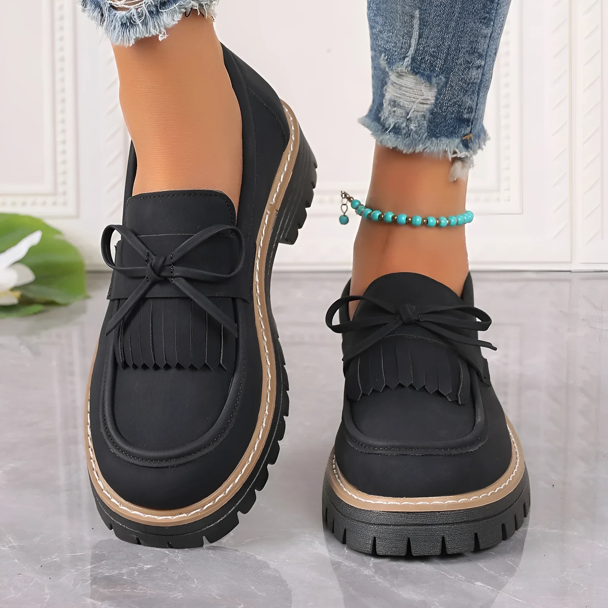 Black and brown plus size women's loafers with tassel detail, chunky heel, and round toe.