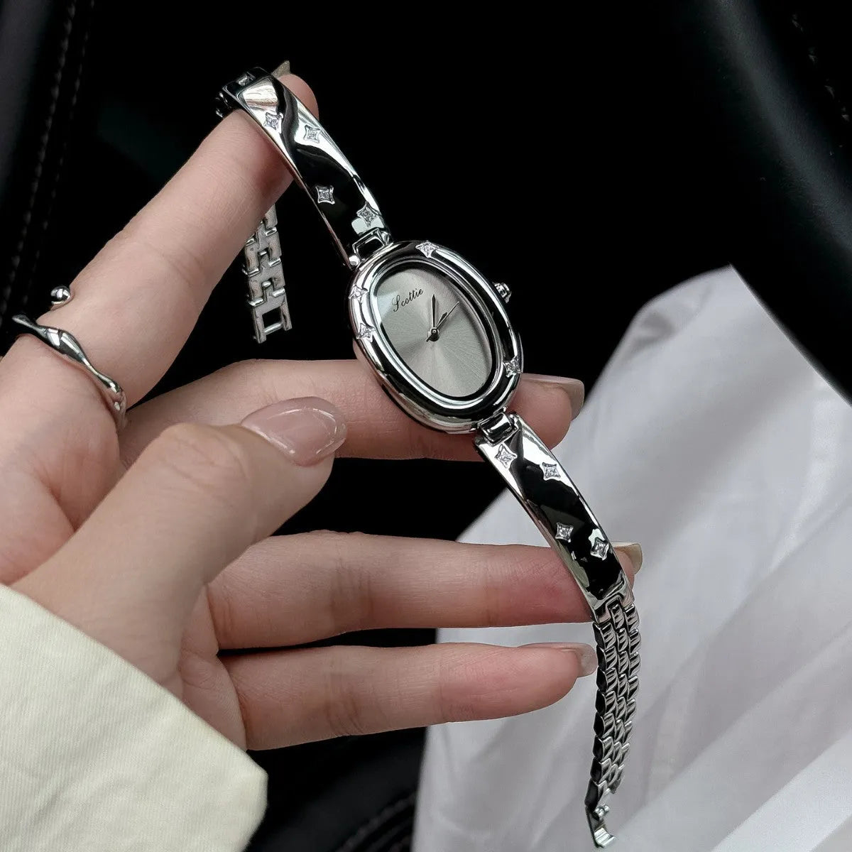 Oval disk bracelet watch with mineral glass mirror and rose gold clasp on a light background