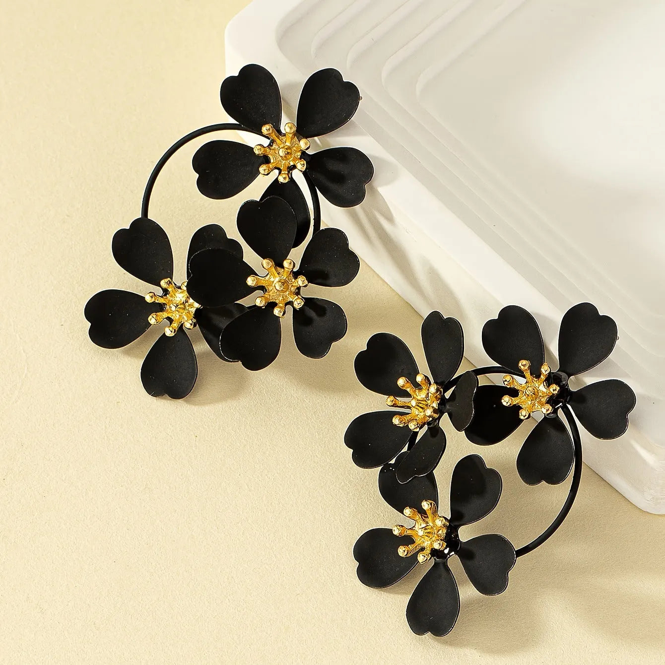 Retro flower-shaped clip-on earrings in black and white colour options