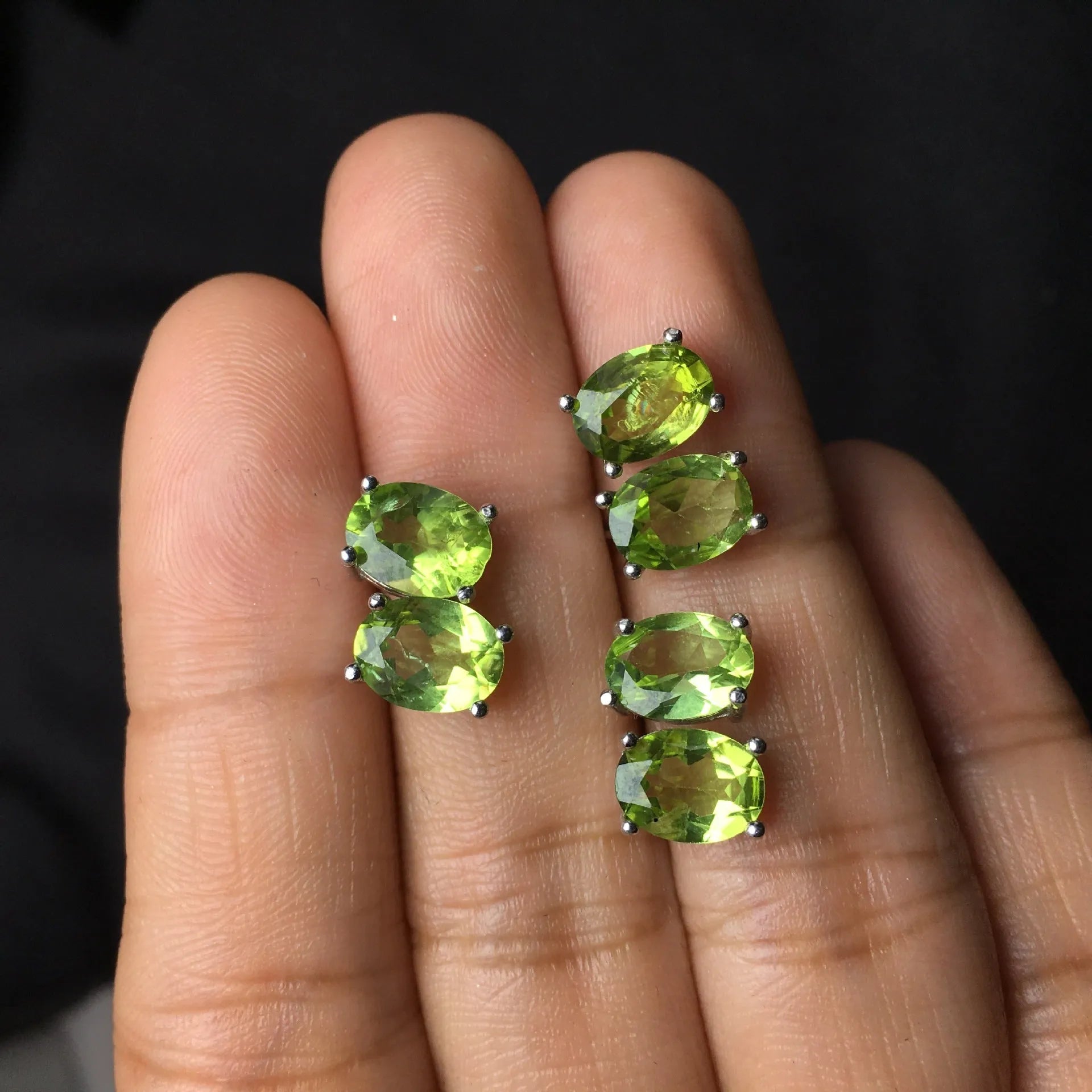 Close-up of natural grass green olivine stud earrings in S925 silver setting.