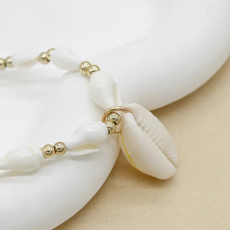 White necklace with a natural shell and mother of pearl pendant on a regular chain.