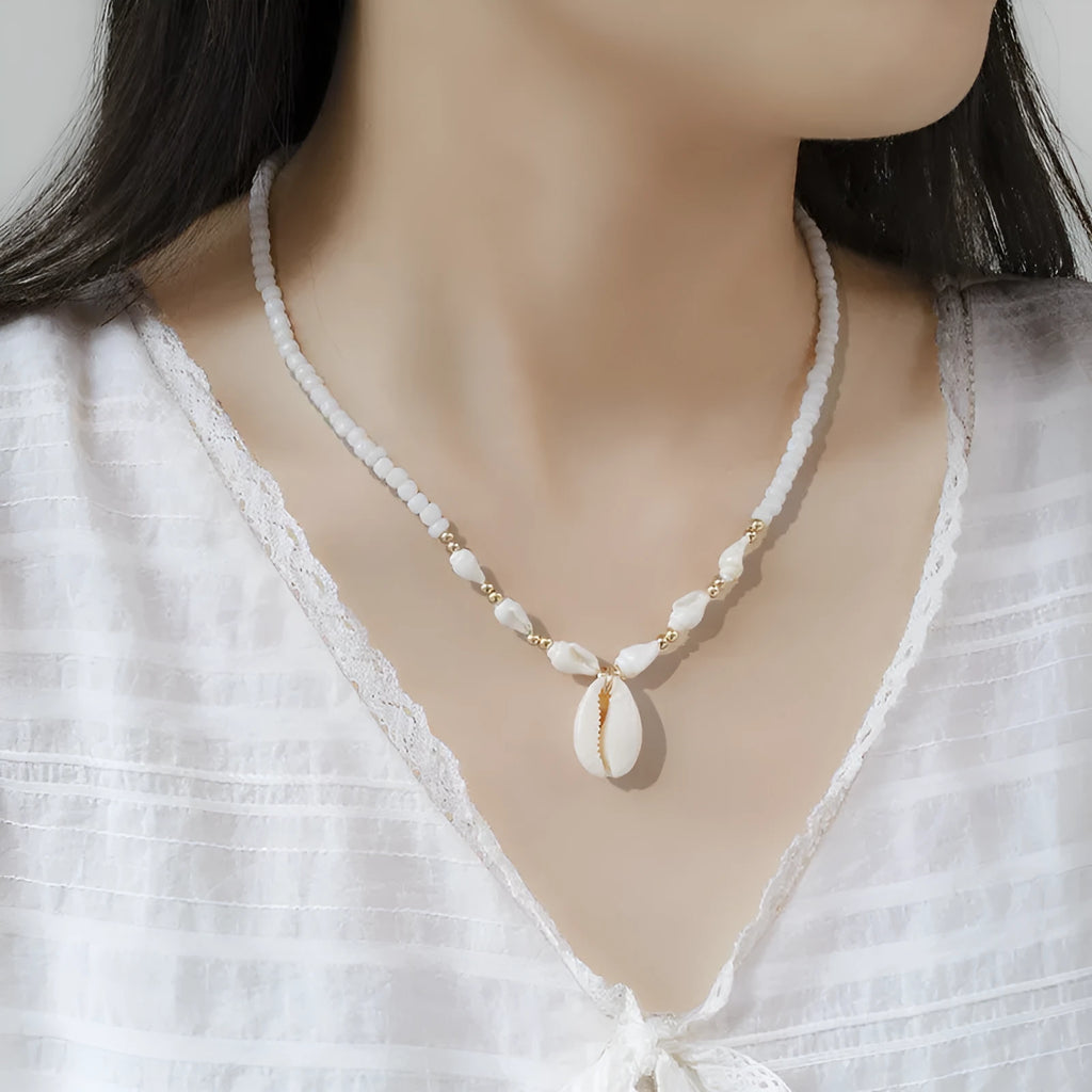 White necklace with a natural shell and mother of pearl pendant on a regular chain.