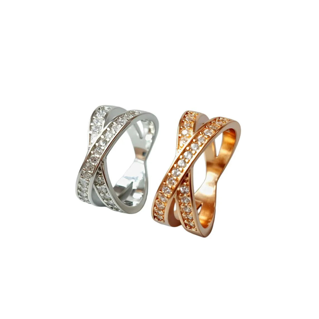 Geometric copper cross ring with micro-inlaid zircon accents in silver or rose gold finish on a finger.
