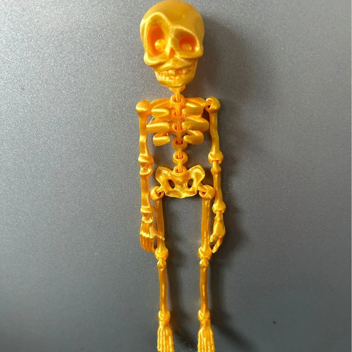 3D printed white skull refrigerator magnet with detailed model on a kitchen fridge.