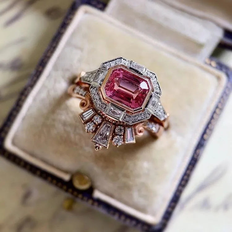 Women's retro-style geometric ruby ring in rose gold alloy on a hand.