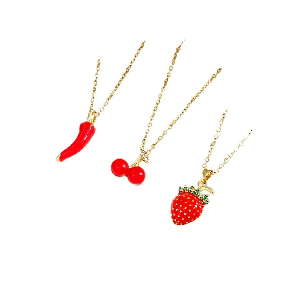 Golden pepper charm on an adjustable titanium steel necklace chain, laid flat.