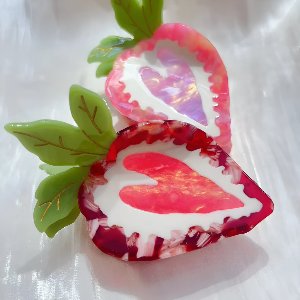 Red and pink strawberry decorative hairpin barrette clip on white background.