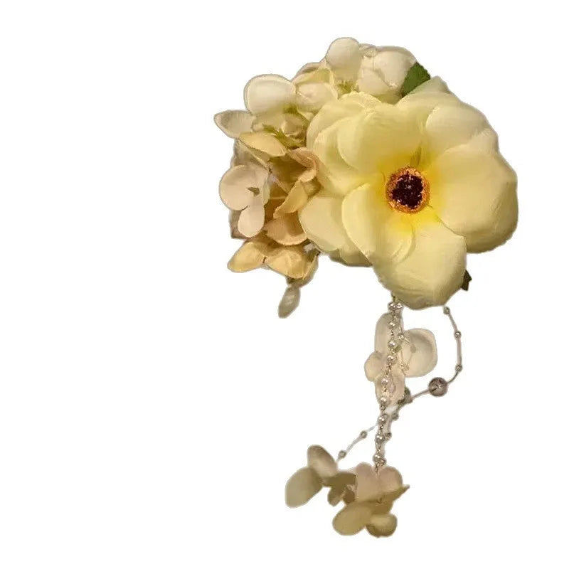 Handmade yellow and purple floral tassel hair clip for women on a white background.