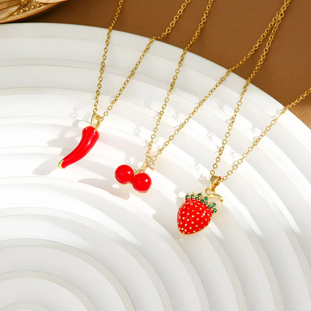 Golden pepper charm on an adjustable titanium steel necklace chain, laid flat.