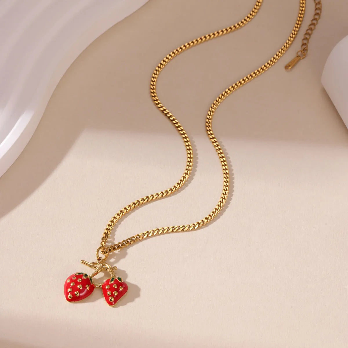 Strawberry fruit charm pendant necklace in stainless steel alloy, shown in red and white gradient colour options.