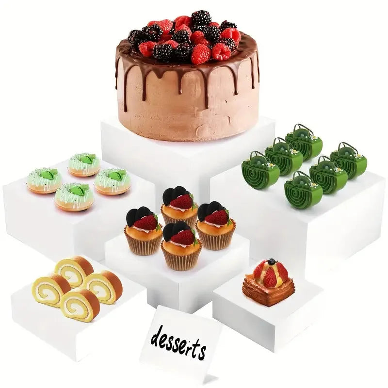 White acrylic six-piece cube dessert display stand arranged on a table with cupcakes.
