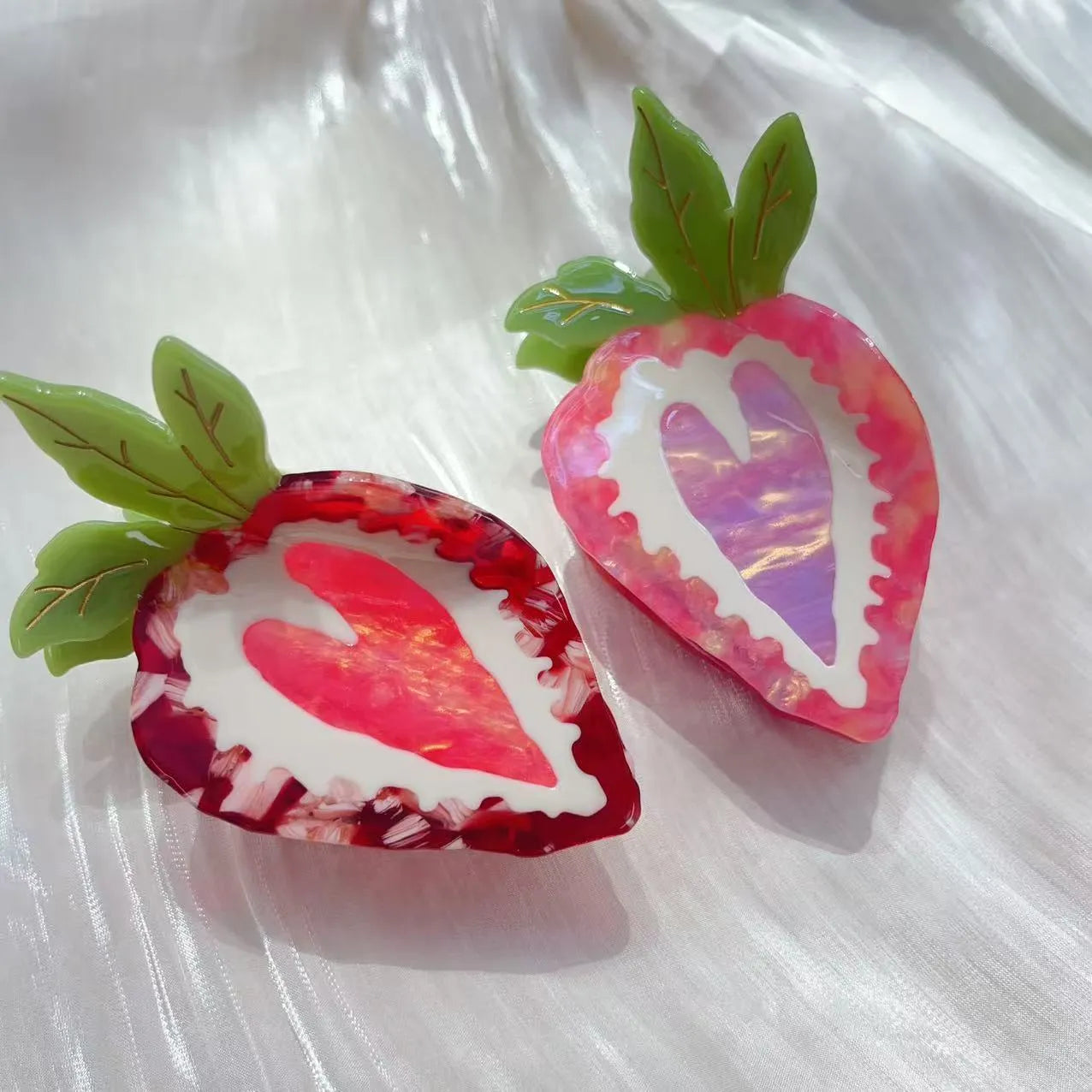 Red and pink strawberry decorative hairpin barrette clip on white background.
