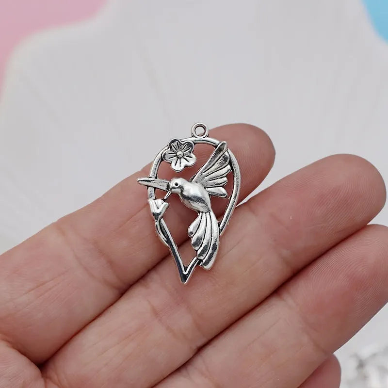 Close-up of a detailed magpie pattern alloy pendant with electroplated finish, showing attachment loop for DIY jewellery.