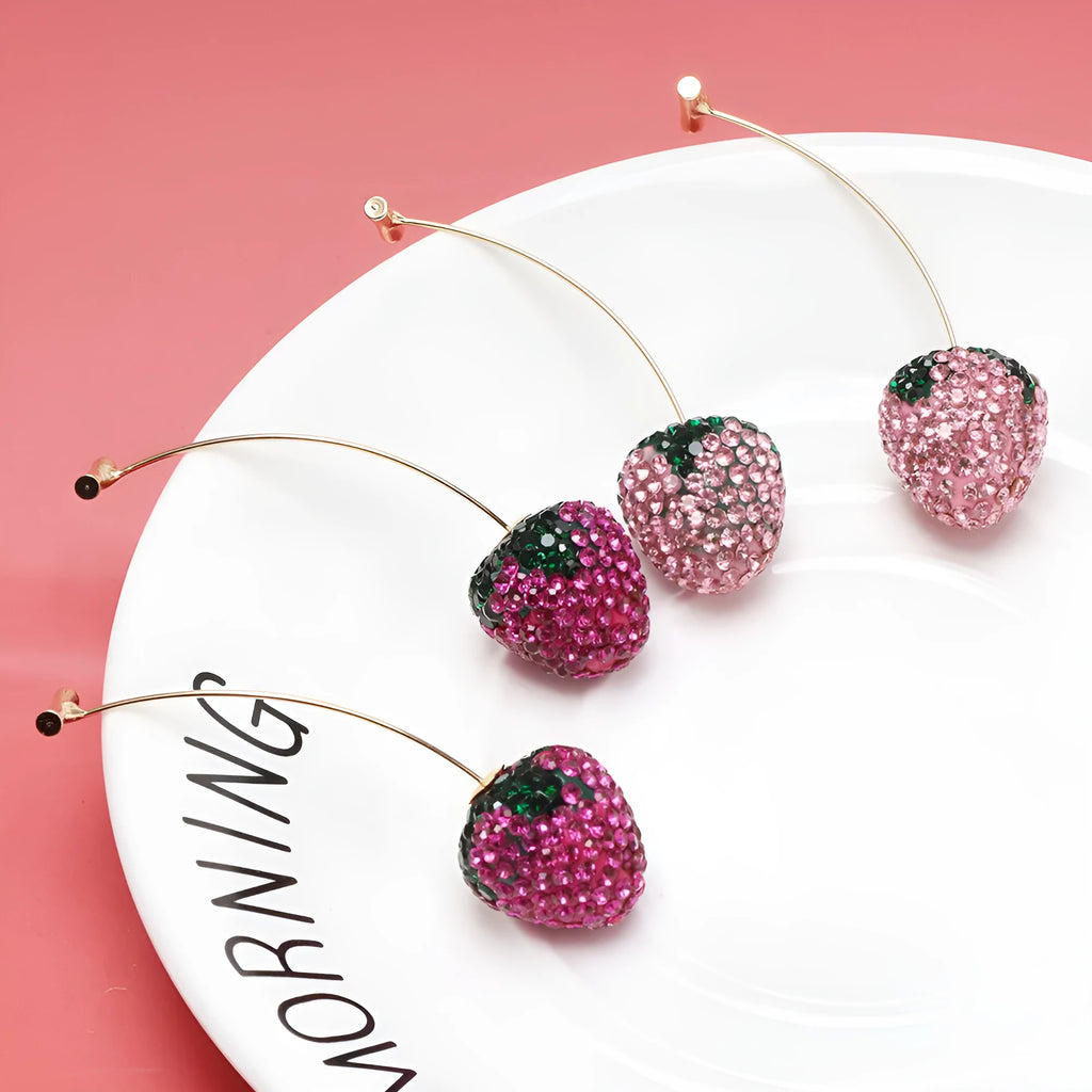 Close-up of women's geometric strawberry-shaped earrings with spot drill texture, on a red background.