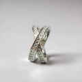 Silver and rose gold metal cross ring with micro-inlaid zircon details on a heart shape.