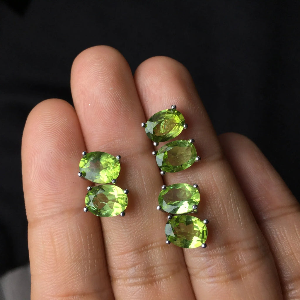Close-up of natural grass green olivine stud earrings in S925 silver setting.