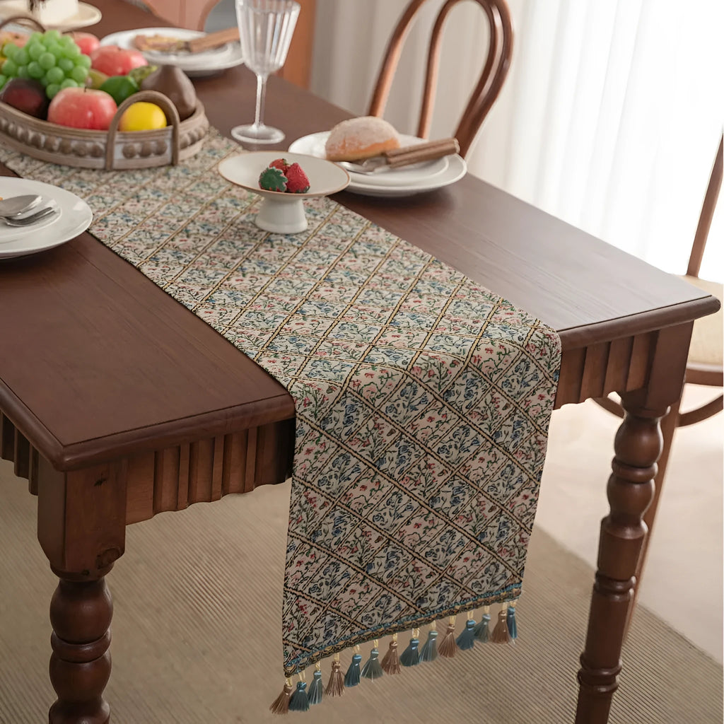 Rhyme Nordic striped jacquard table runner with tassel fringe in dark blue on a wooden table.
