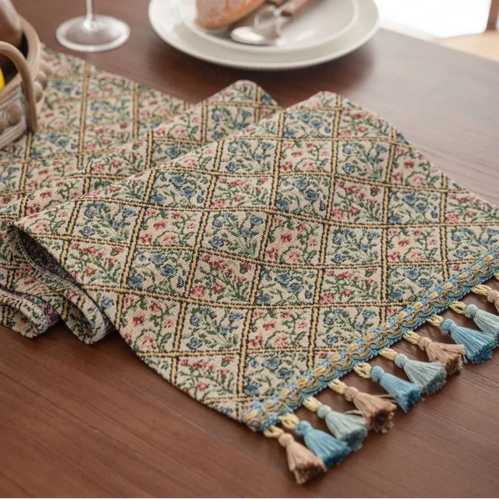 Rhyme Nordic striped jacquard table runner with tassel fringe in dark blue on a wooden table.