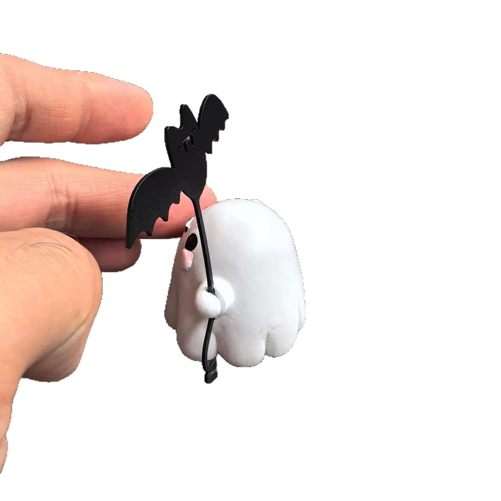 Miniature hand-painted resin statue of a cartoon ghost walking a bat, a Halloween ornament.