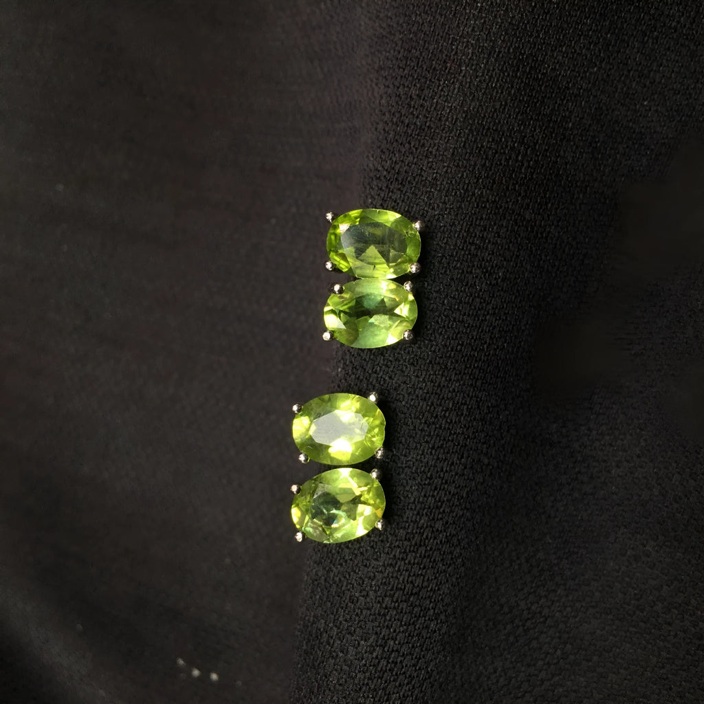 Close-up of natural grass green olivine stud earrings in S925 silver setting.