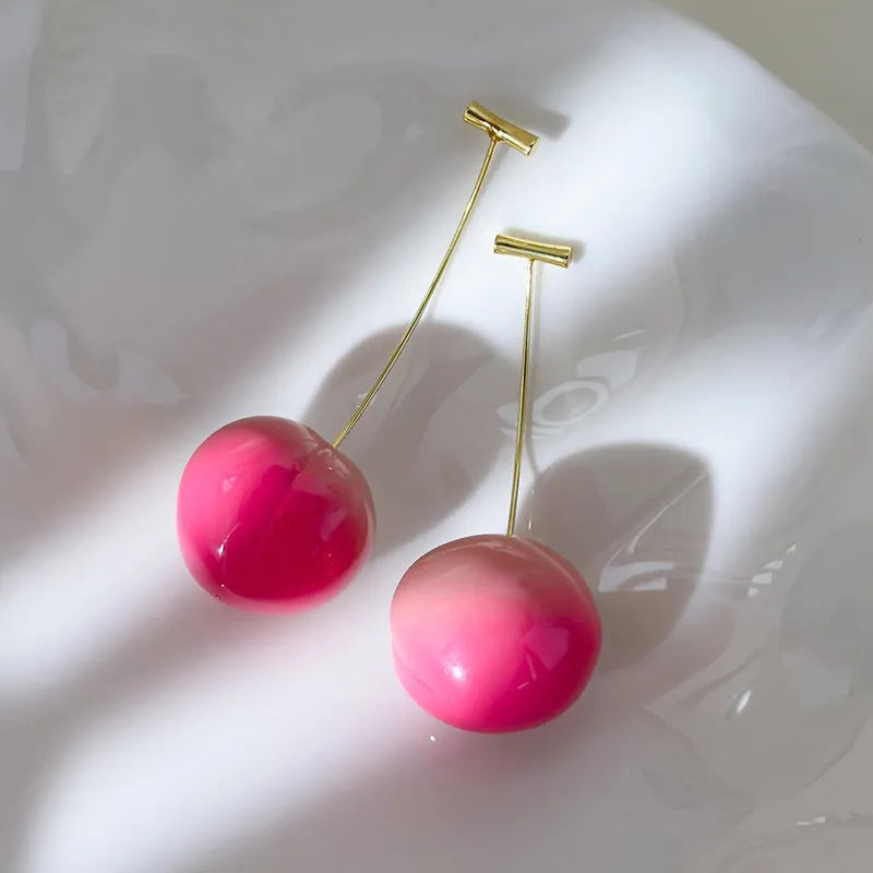 A pair of peach-shaped acrylic earrings on copper posts, shown in a choice of large or small sizes.