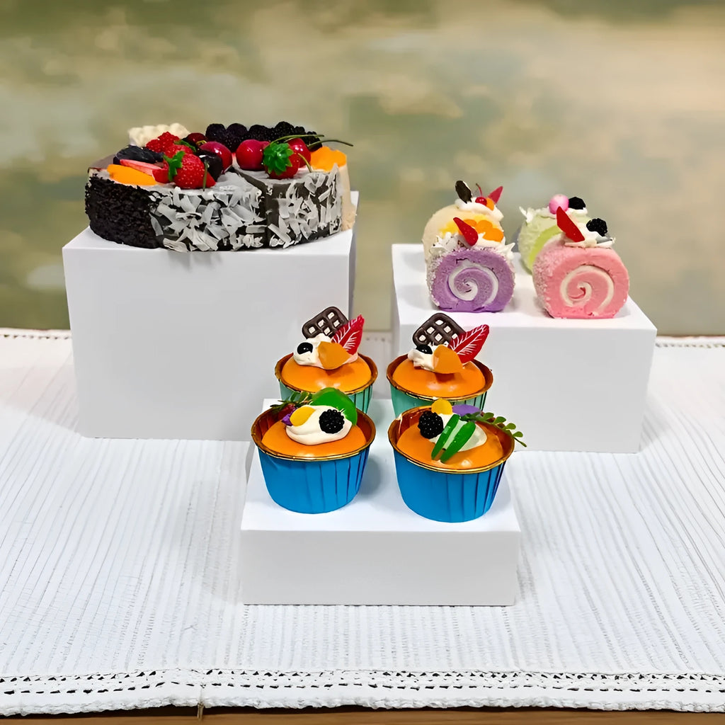 White acrylic six-piece cube dessert display stand arranged on a table with cupcakes.