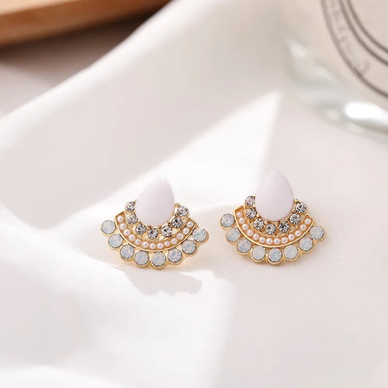 Close-up of women's retro silver fan-shaped rhinestone earrings with needle posts.