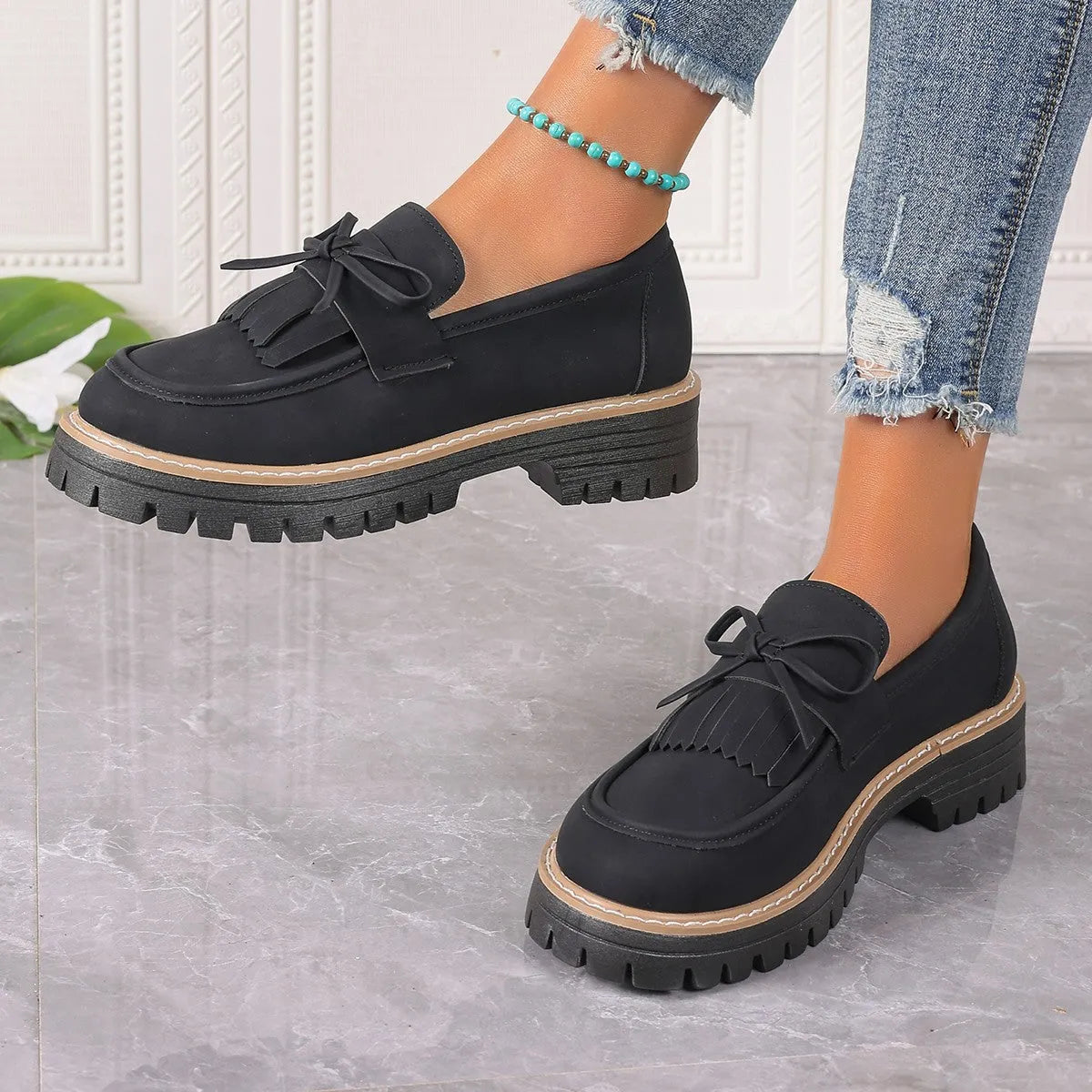 Black and brown plus size women's loafers with tassel detail, chunky heel, and round toe.