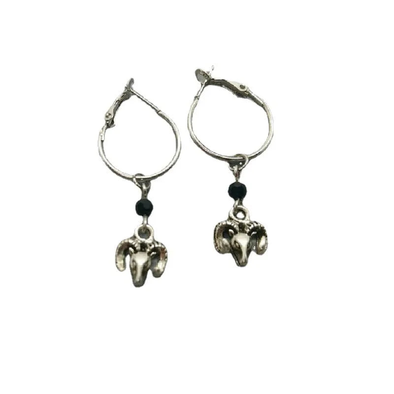 A pair of silver-coloured round hoop earrings with a Tibetan antelope design.
