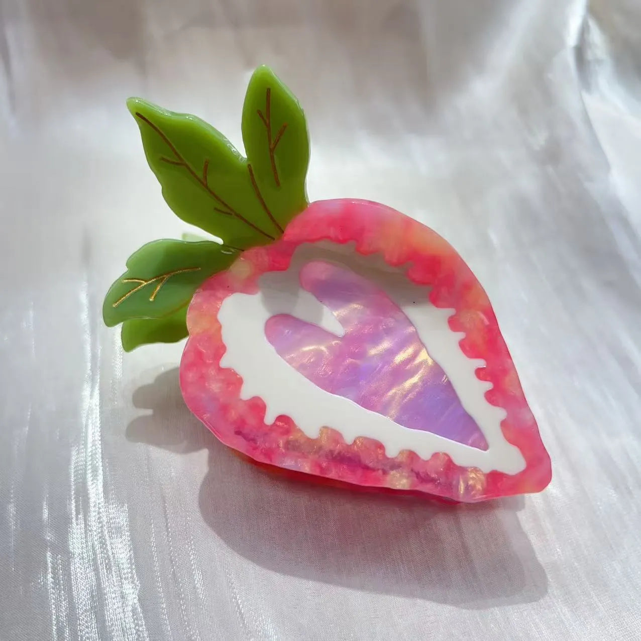 Red and pink strawberry decorative hairpin barrette clip on white background.