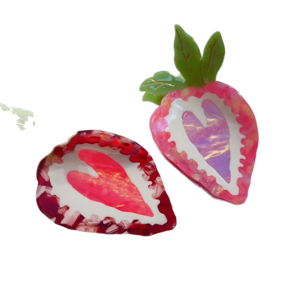 Red and pink strawberry decorative hairpin barrette clip on white background.