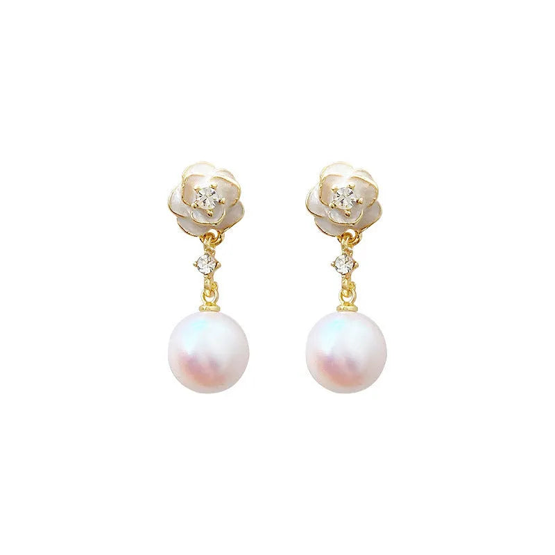 Gold-tone camellia flower stud earrings with a white crystal pearl in the centre on a white background.