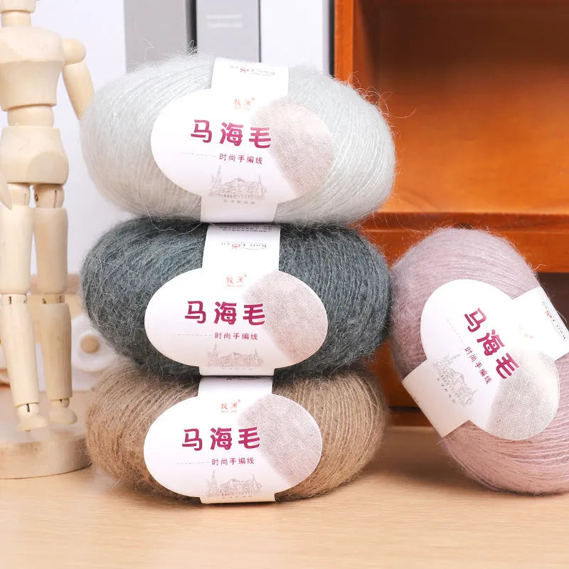 Hand-woven DIY mohair scarf kit with wool ball, shown in a selection of colours including beige, pink, and blue.