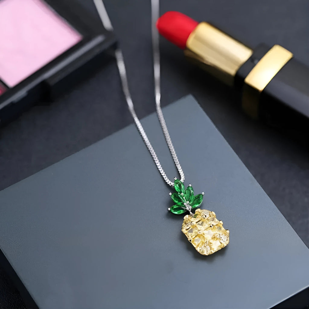 Women's silver tone necklace with a geometric pineapple and diamond motif pendant on a chain.