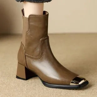 Brown cowhide leather women's Martin boots with high heel and side zipper on a white background.