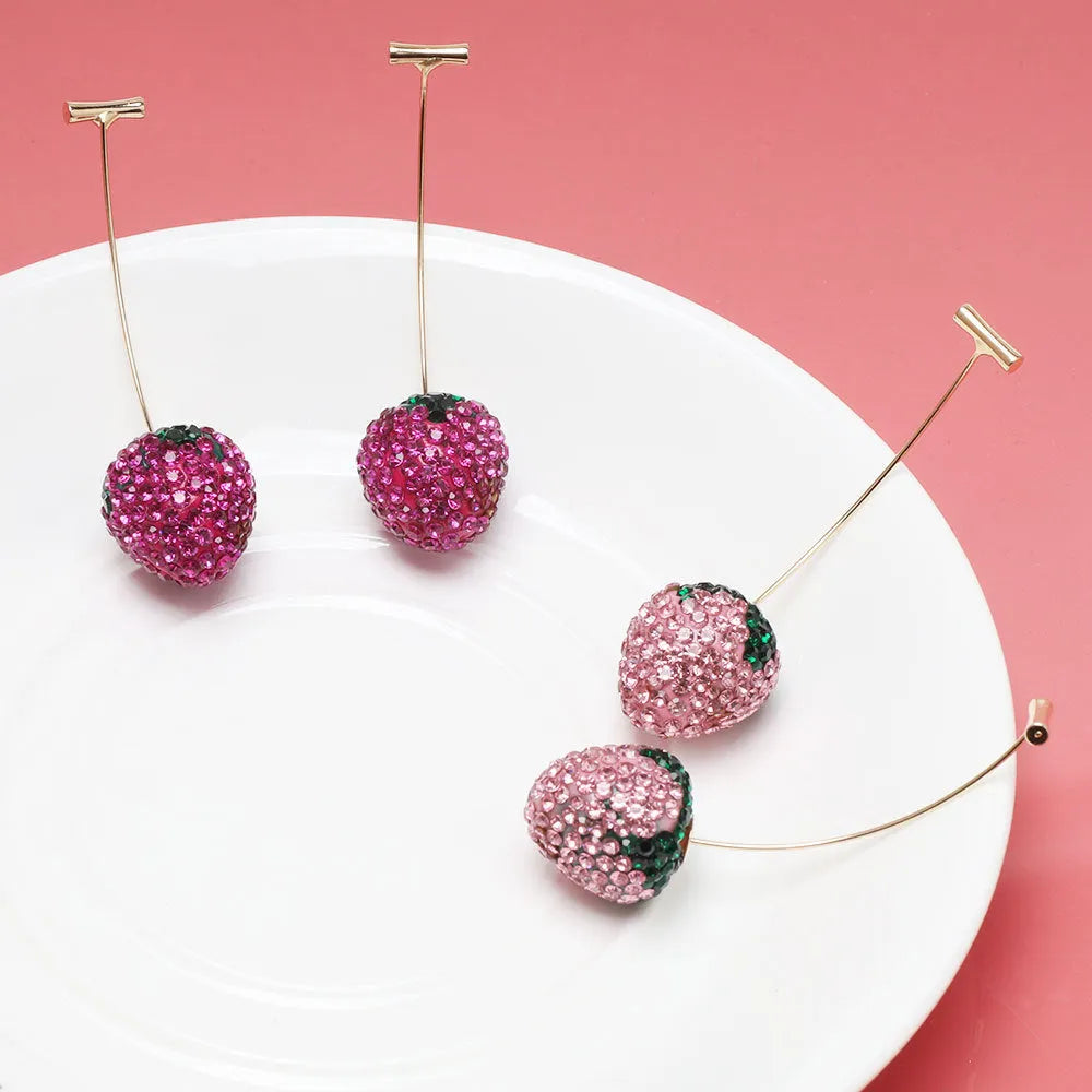 Close-up of women's geometric strawberry-shaped earrings with spot drill texture, on a red background.