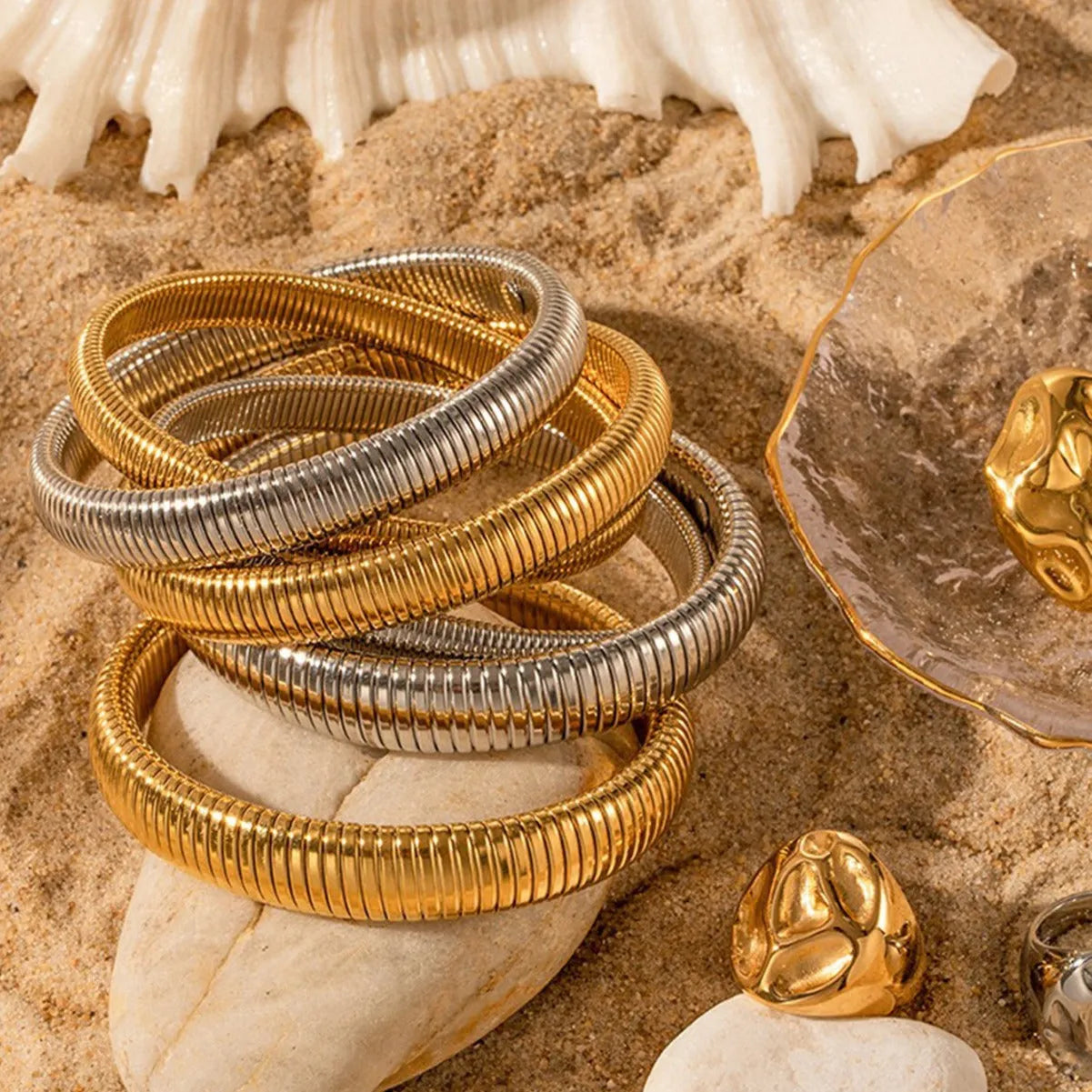 Gold elastic titanium steel bracelet with a wide vertical stripe ring pattern on a wrist.