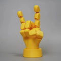 Yellow PLA hand ornament with movable joints on a white background.