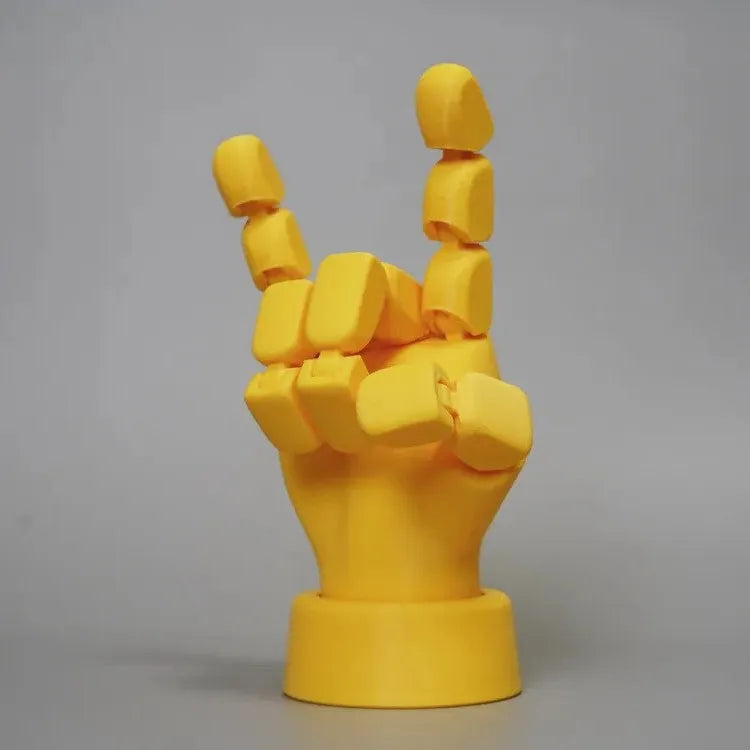 Yellow articulated hand prop with movable finger joints on a white background.